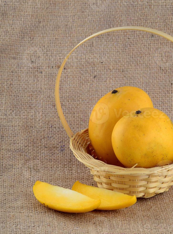 fruta da manga na cesta no fundo do pano de saco foto
