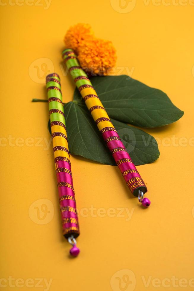 festival indiano dussehra e navratri, mostrando folhas douradas de bauhinia racemosa e flores de calêndula com paus de dandiya. foto