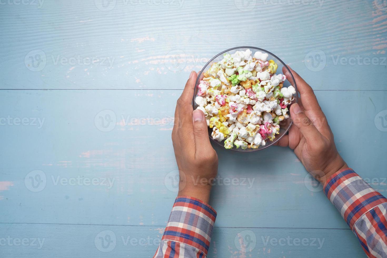 jovem comendo pipoca vista de cima foto