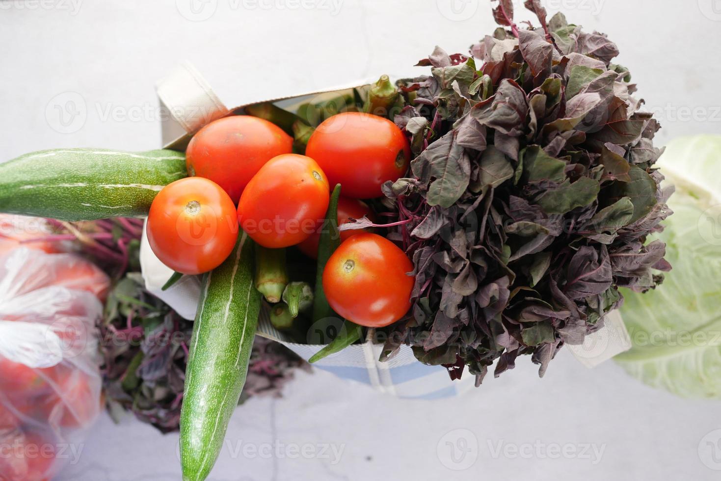 vista superior de vegetais em uma sacola de compras de plástico no chão foto