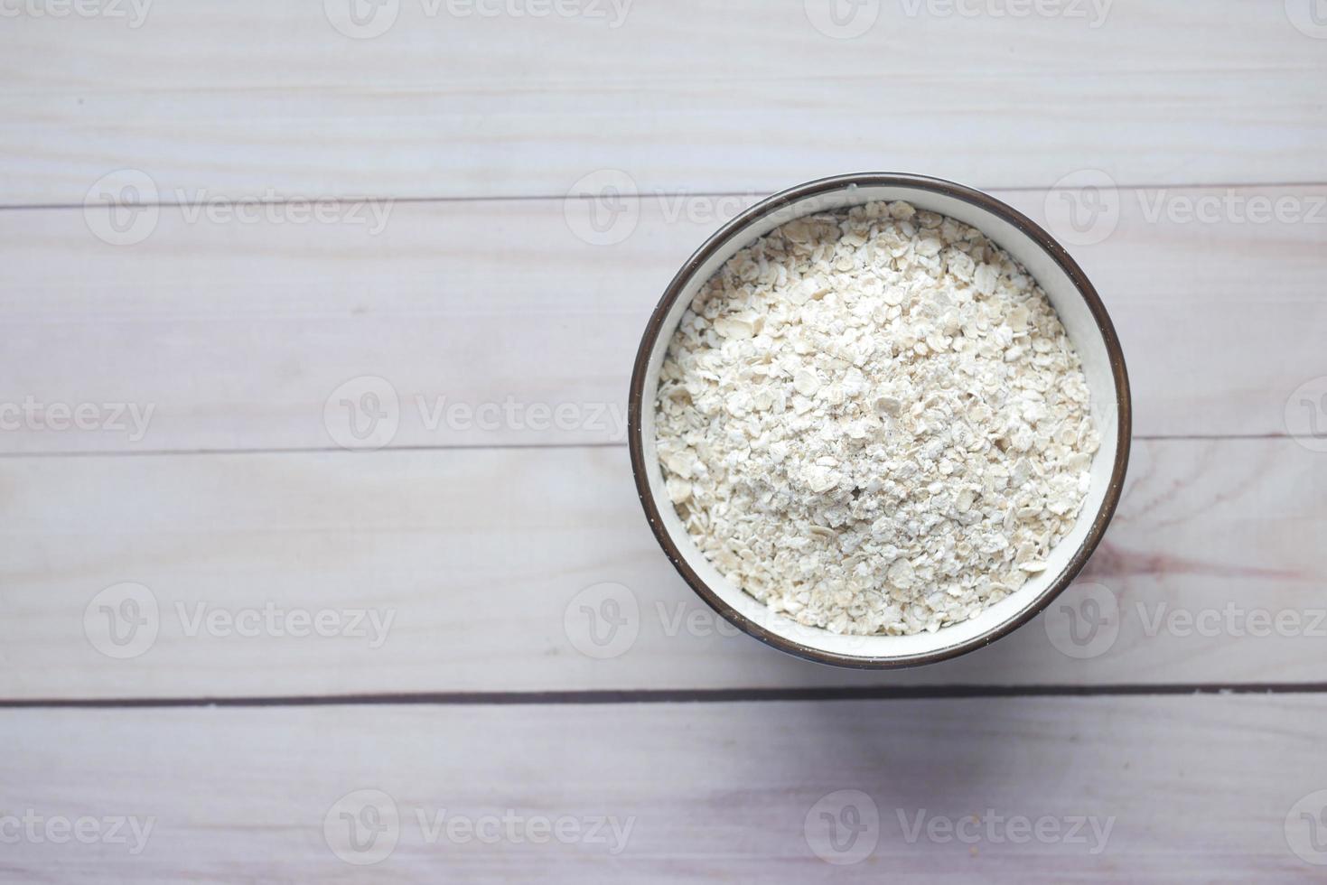 close-up de flocos de aveia em uma tigela na mesa foto