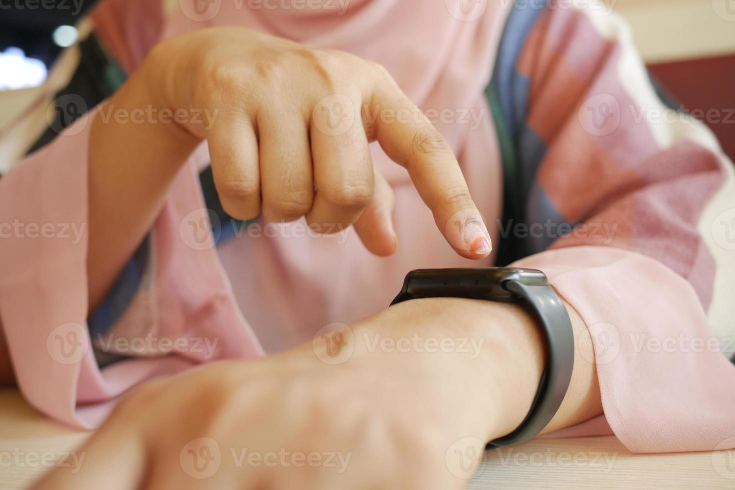as mãos das mulheres verificando as horas no relógio inteligente, foto