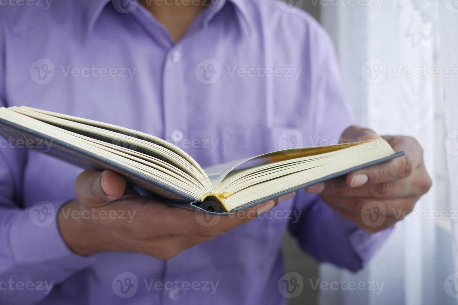 Mão de homem muçulmano segurando o livro sagrado Alcorão com espaço de cópia foto