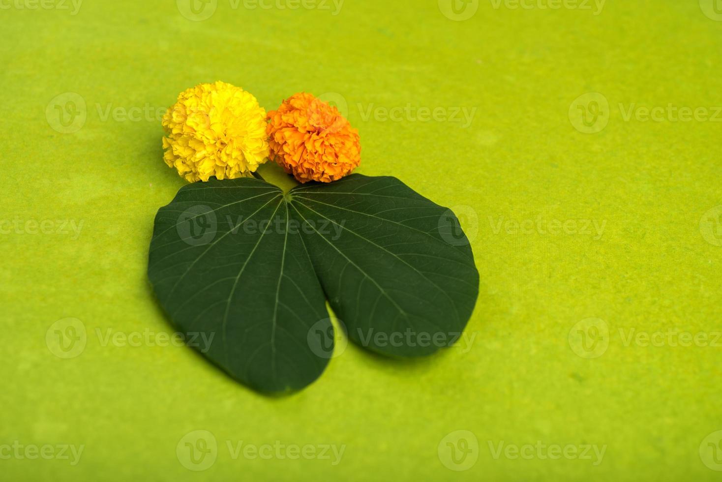 festival indiano dussehra, mostrando folhas douradas bauhinia racemosa e flores de calêndula em um fundo marrom. foto
