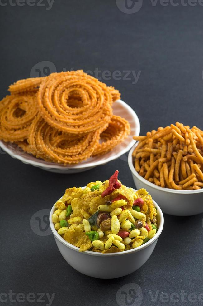 lanche indiano chakli, chakali ou murukku e besan grama farinha sev e chivada ou chiwada. comida diwali foto