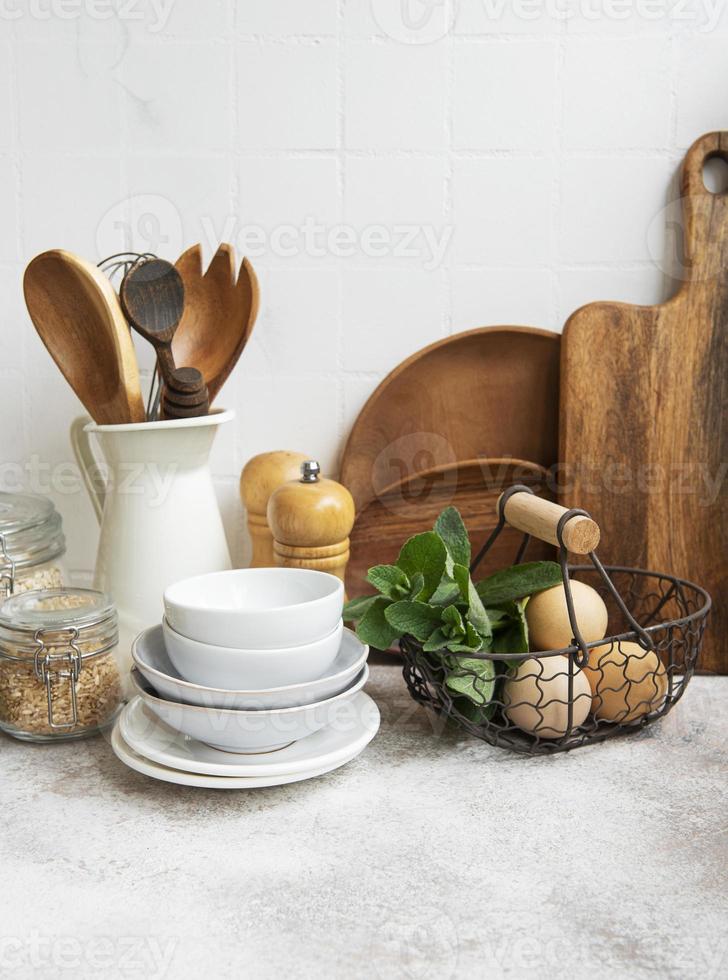 utensílios de cozinha, ferramentas e louças na parede de azulejos brancos de fundo. foto