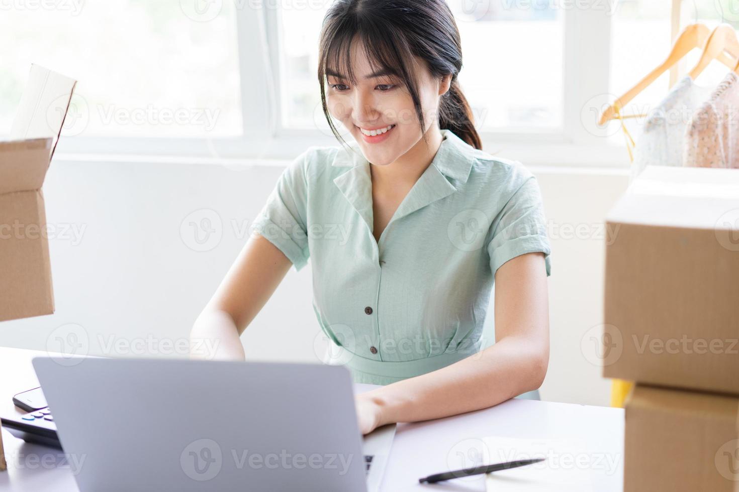 jovem asiática começando uma carreira de vendas online em casa foto