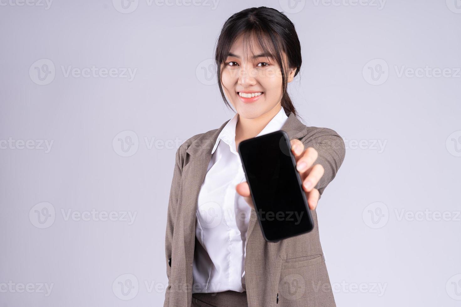 jovem empresária asiática usando telefone no fundo branco foto