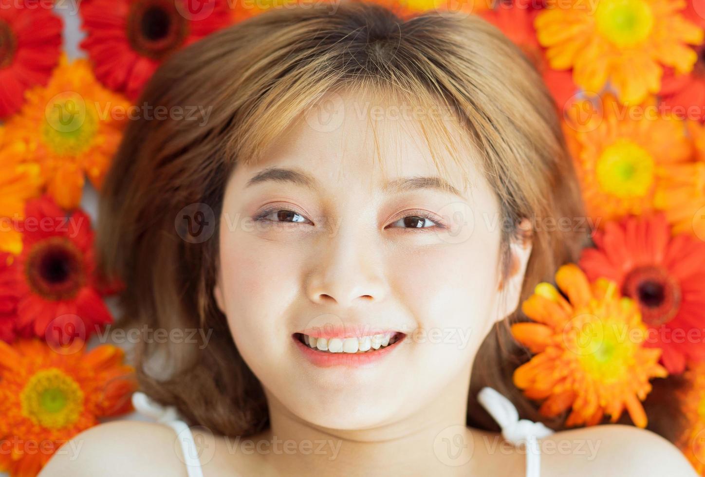 jovem deitada em uma flor com uma expressão feliz foto