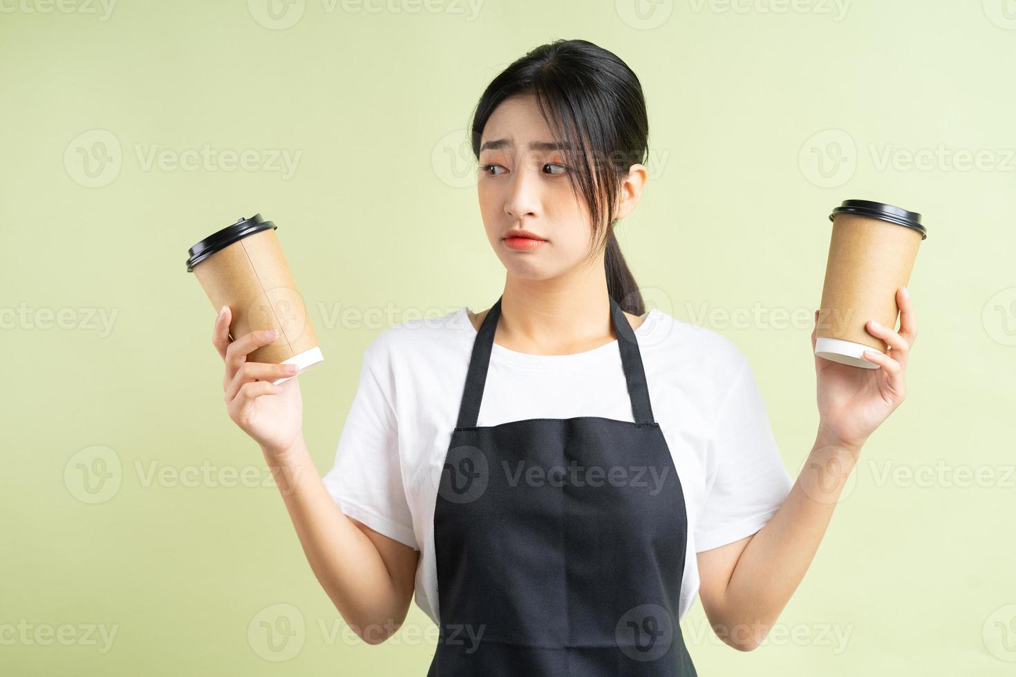 garçonete asiática segurando duas xícaras de café foto