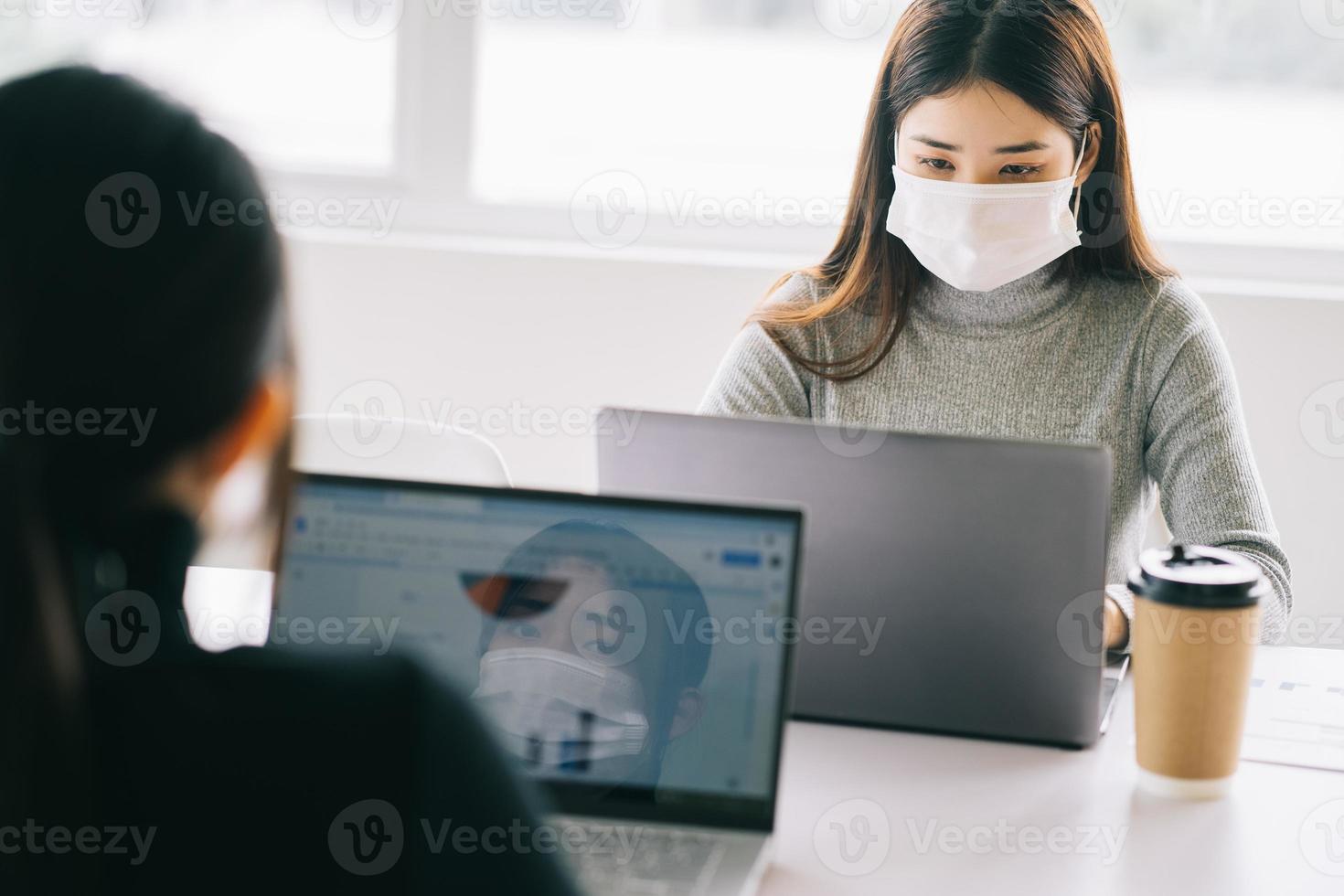 duas mulheres têm que usar máscaras durante o horário de trabalho para se manter seguras durante as epidemias foto