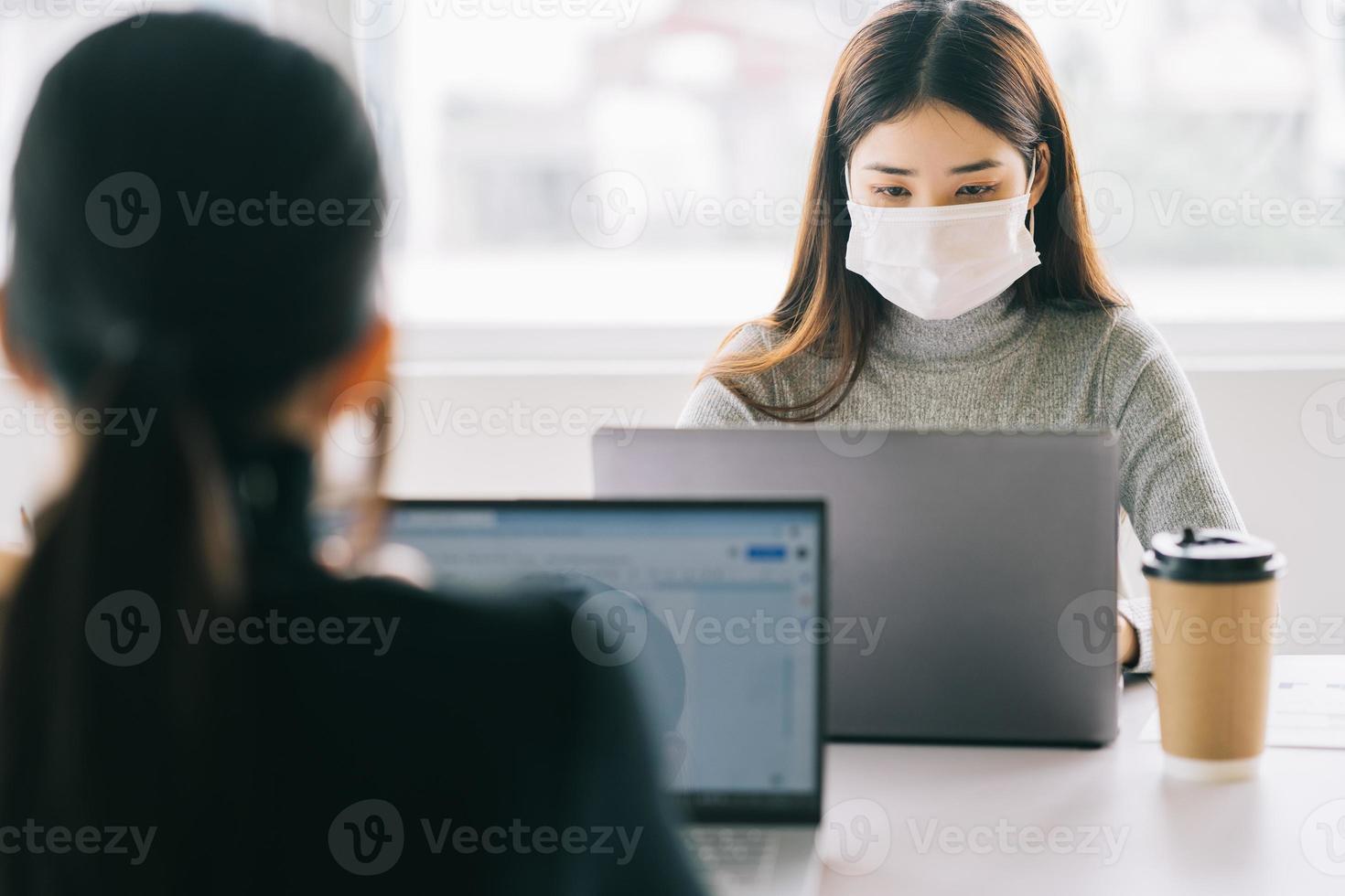 duas mulheres têm que usar máscaras durante o horário de trabalho para se manter seguras durante as epidemias foto