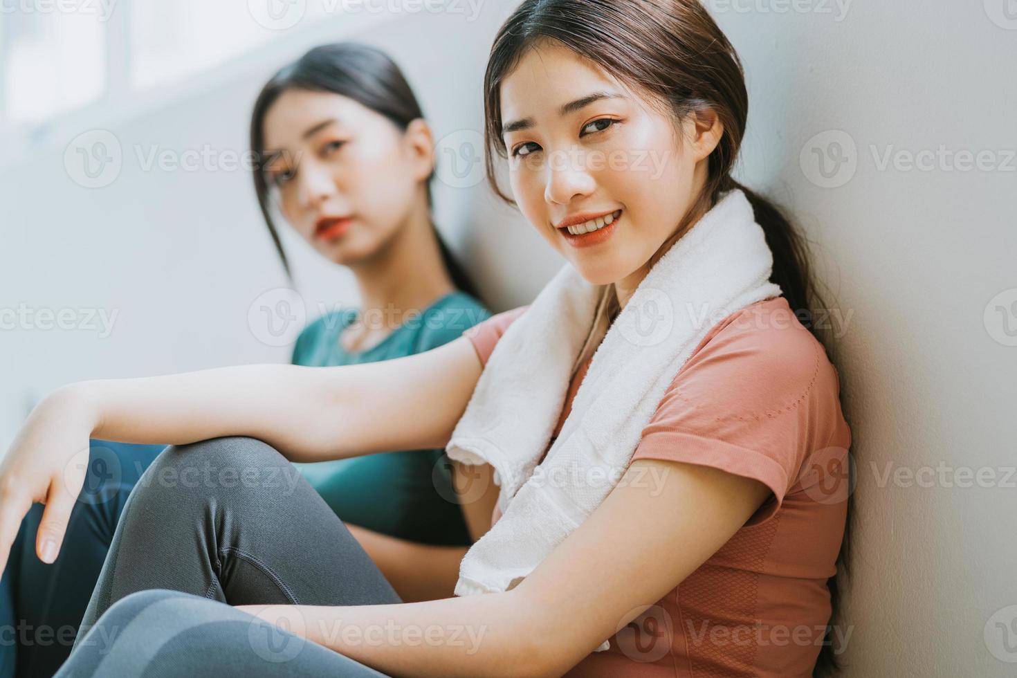 duas mulheres asiáticas fazendo uma pausa na sessão de ioga foto