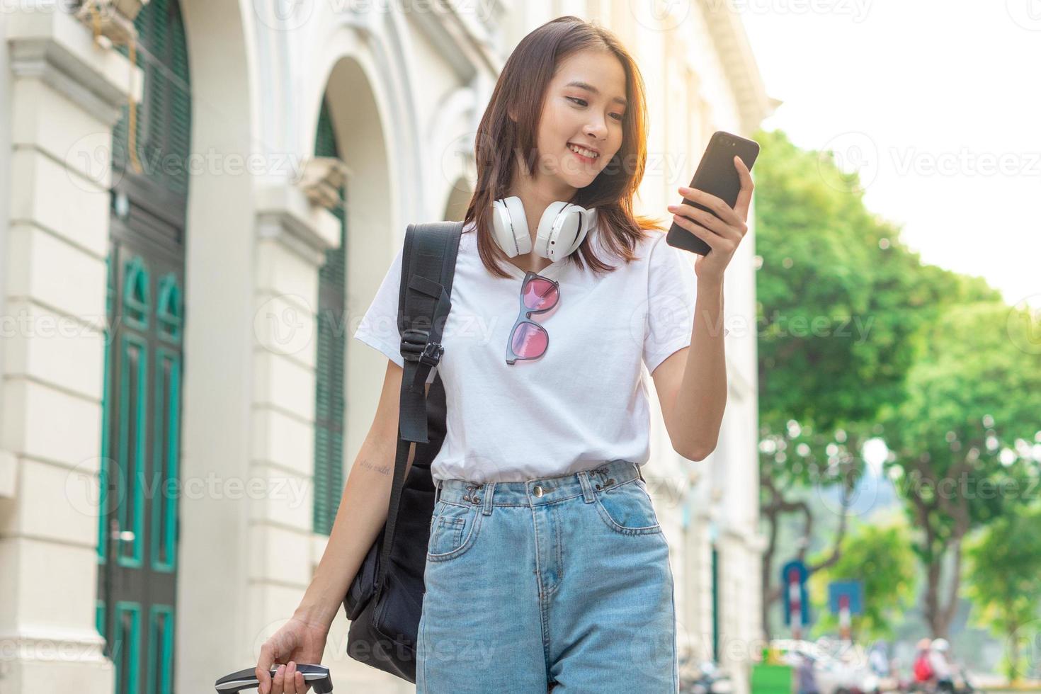 turista asiática usando o telefone para encontrar o caminho foto