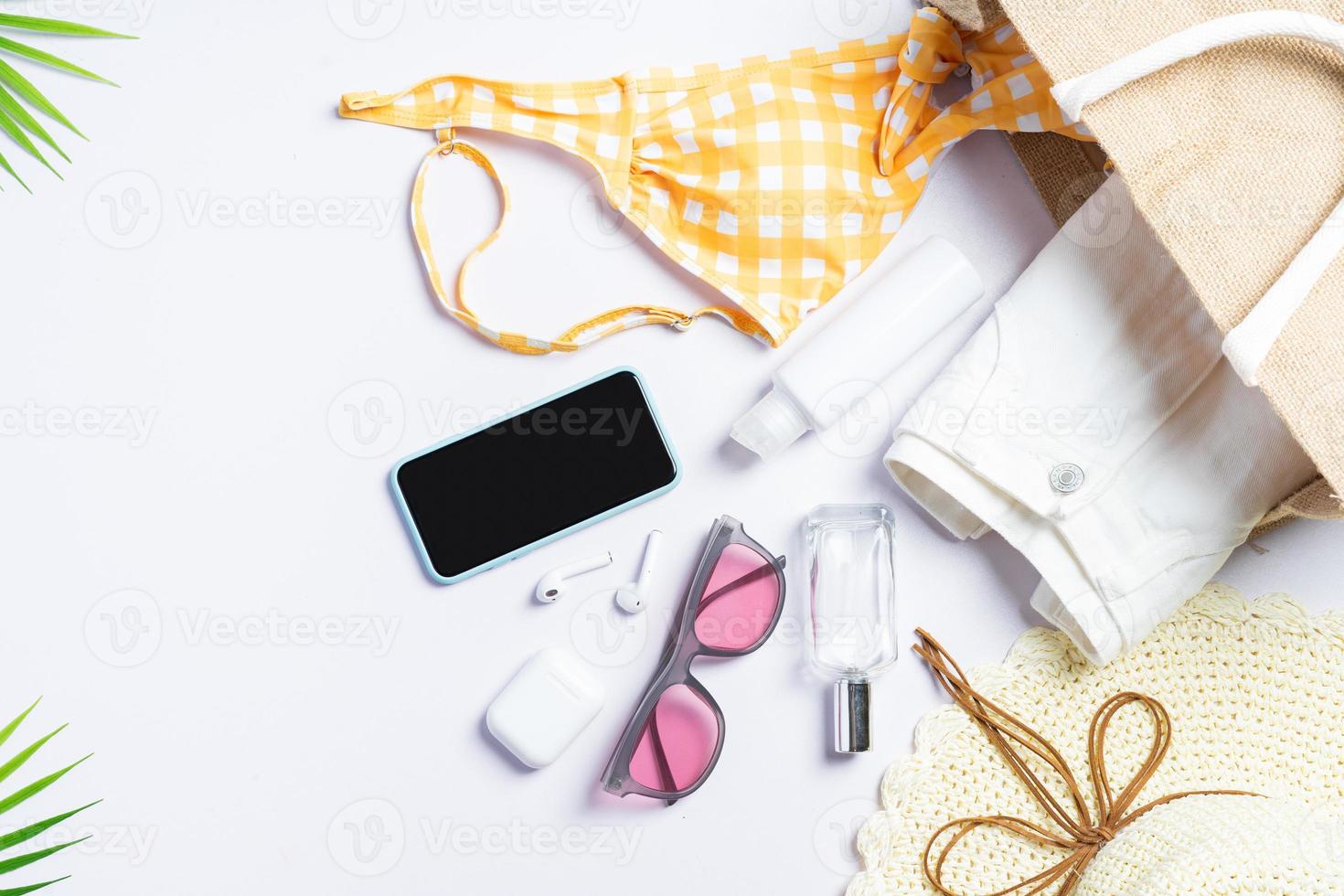 foto de vista superior de uma bolsa de viagem feminina com itens dentro, conceito de verão