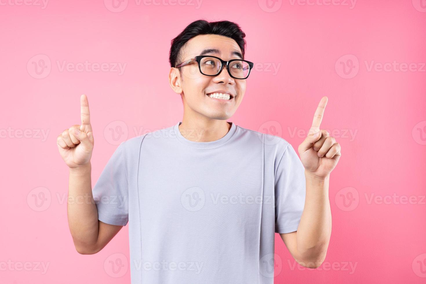 retrato de homem asiático posando em fundo rosa com muitas expressões foto