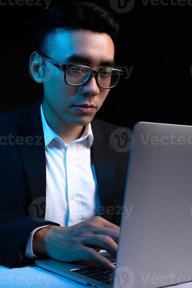 retrato de um programador asiático trabalhando à noite foto