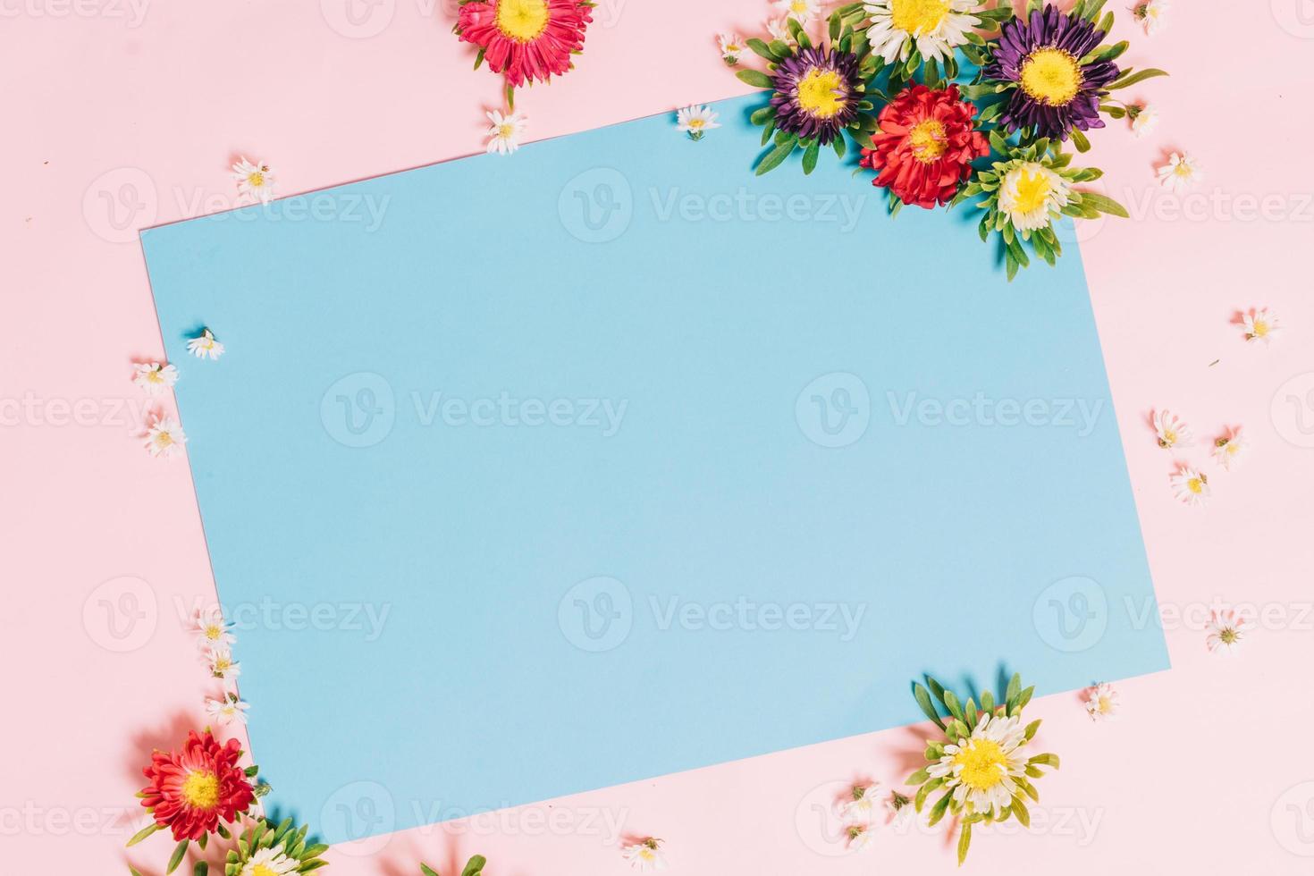 o papel azul é colocado em um fundo rosa com flores ao redor de hoa foto