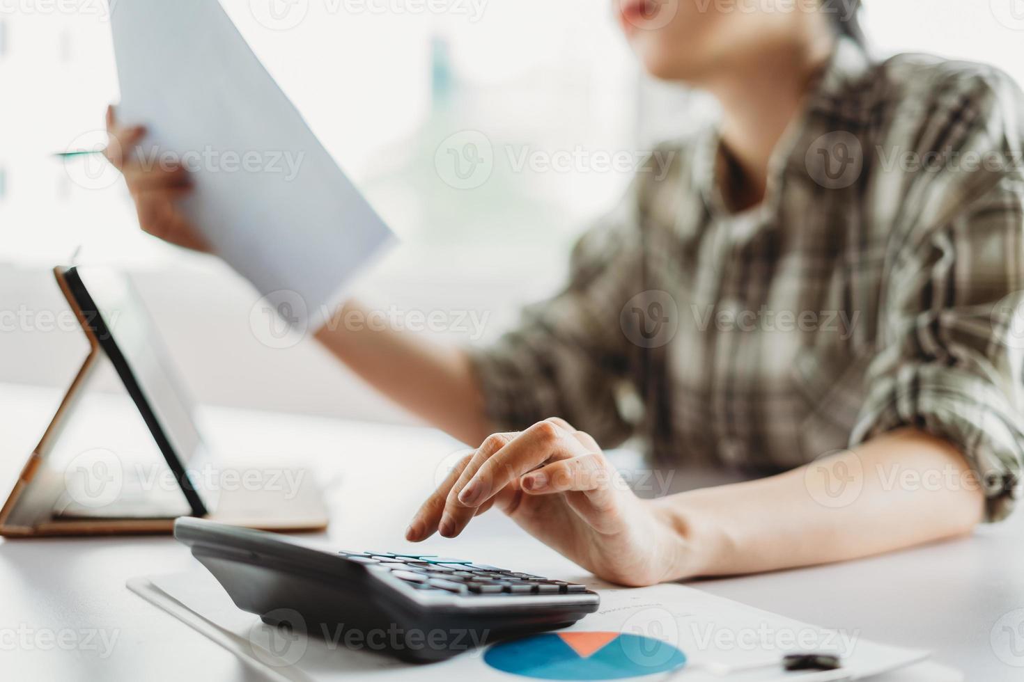 jovem mulher asiática está calculando o imposto a pagar foto