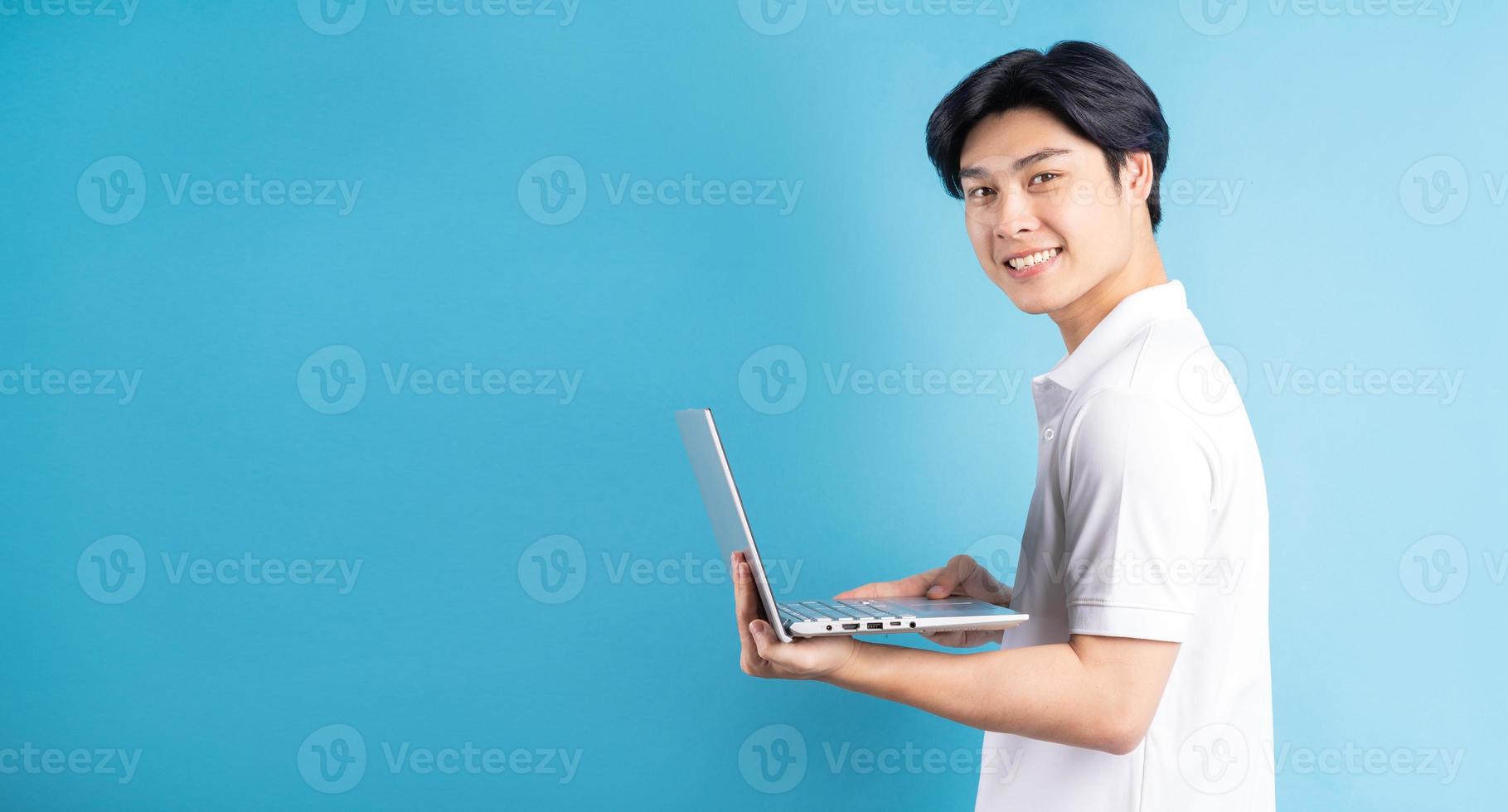 homem asiático está digitando em um fundo azul foto