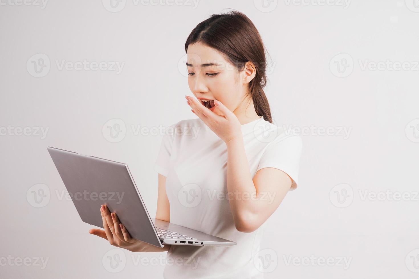 retrato de uma jovem segurando o computador no fundo branco foto