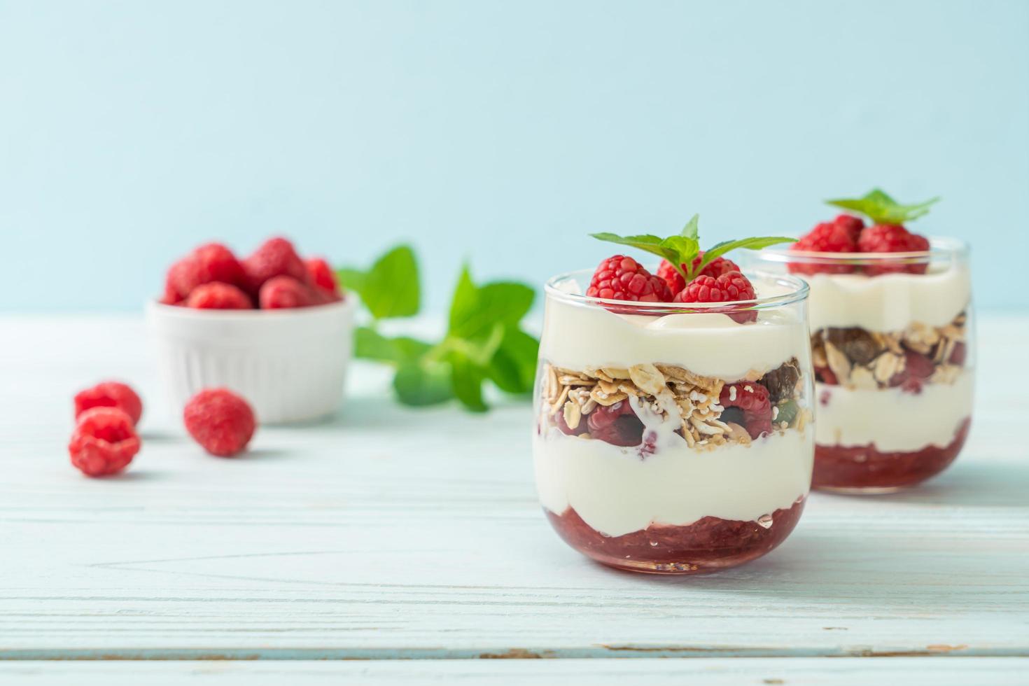 Framboesa fresca e iogurte com granola - estilo de comida saudável foto