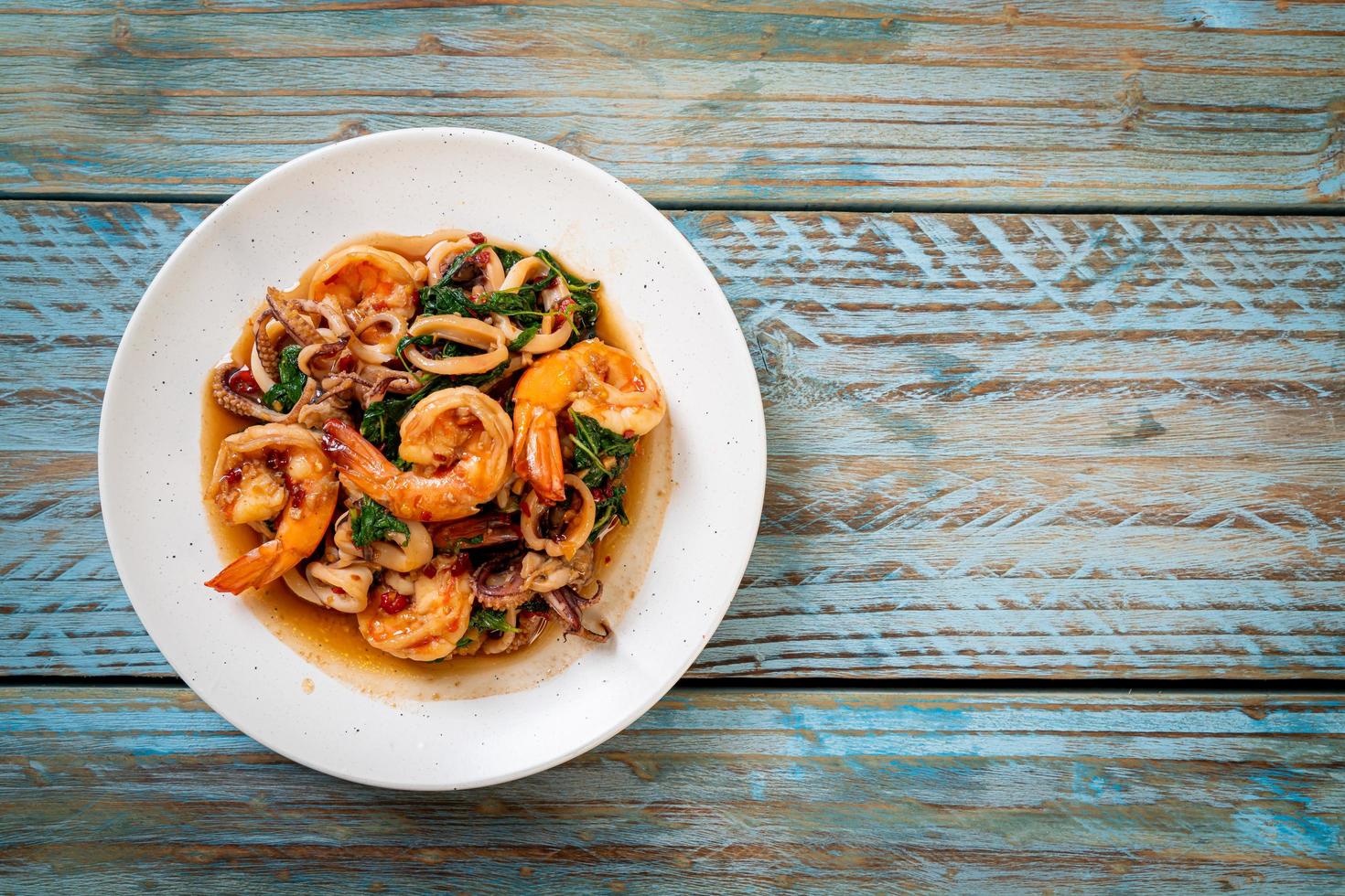 Frutos do mar de camarão e lula fritos com manjericão tailandês - comida asiática foto