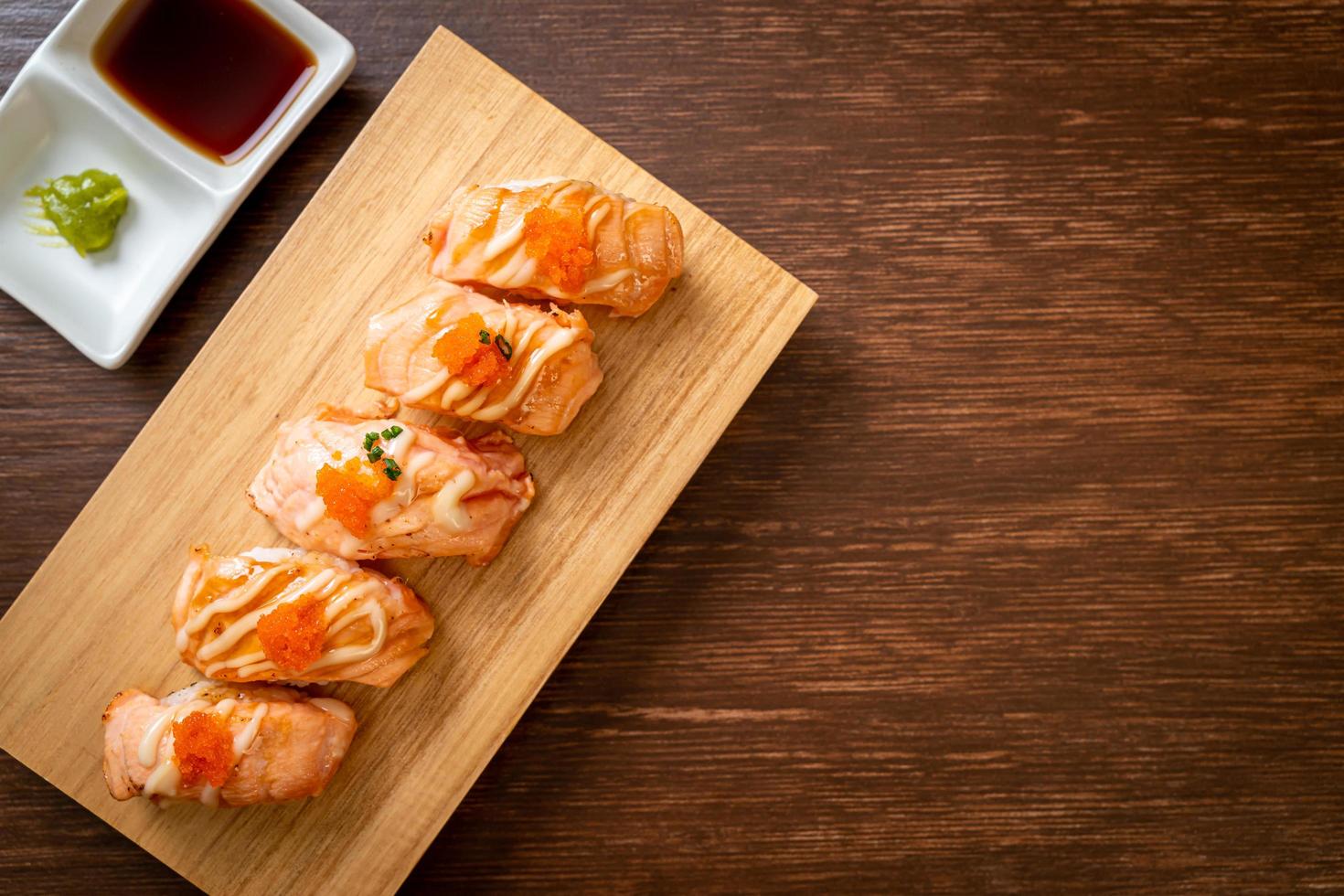 Sushi de salmão grelhado em um prato de madeira - estilo comida japonesa foto