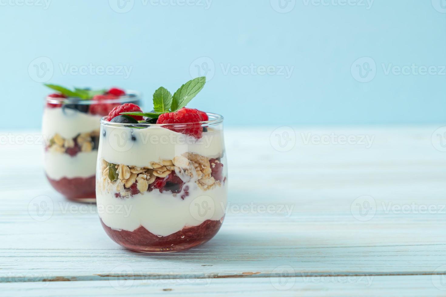 Framboesa e mirtilo caseiros com iogurte e granola - estilo de comida saudável foto