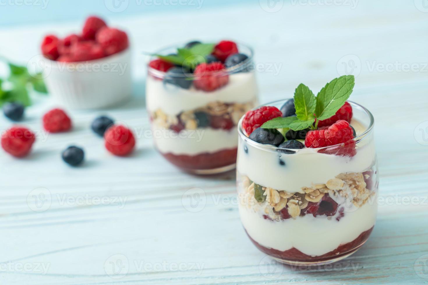 Framboesa e mirtilo caseiros com iogurte e granola - estilo de comida saudável foto