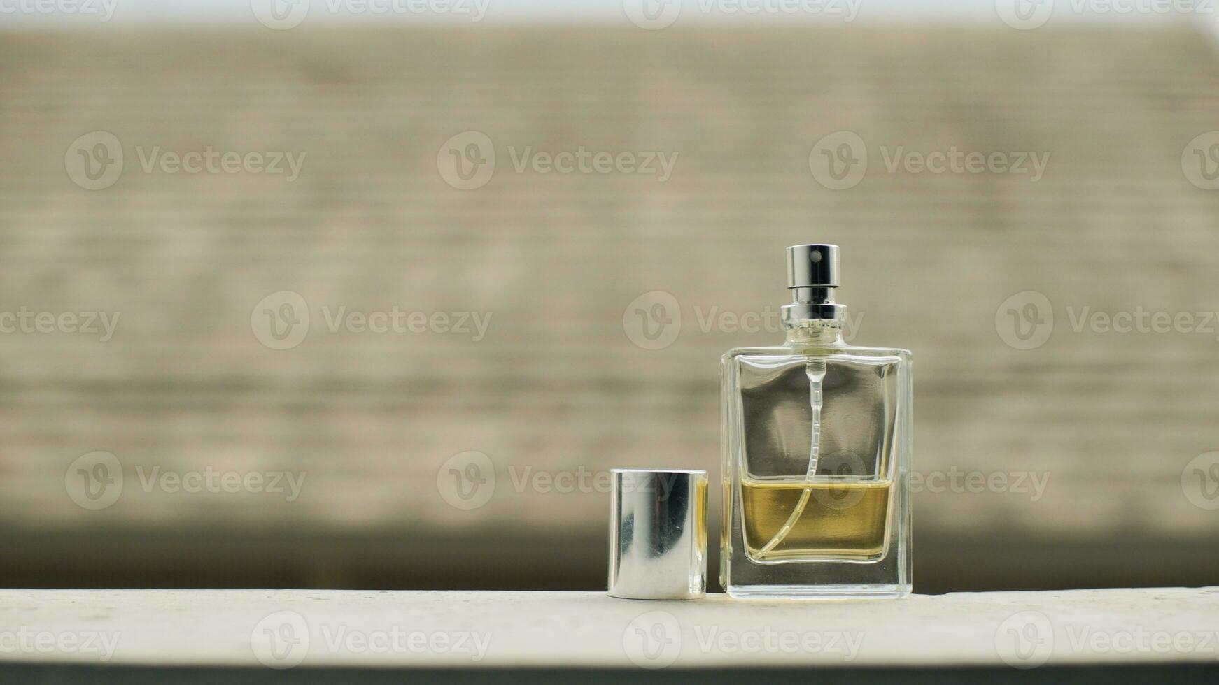 pequeno transparente perfume garrafa preenchidas com amarelo líquido em mesa com minimalista embaçado fundo. foto