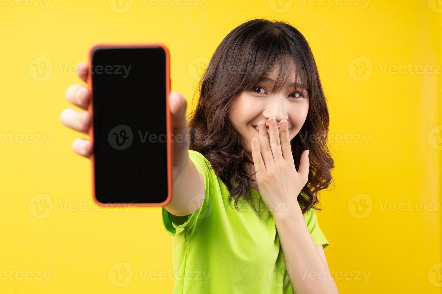 jovem usando o telefone com uma expressão alegre no fundo foto