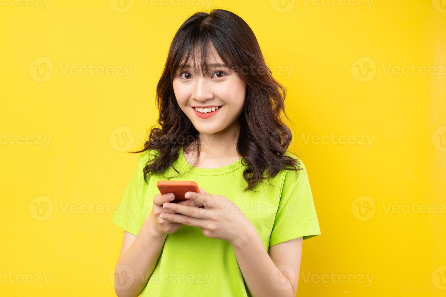 jovem usando o telefone com uma expressão alegre no fundo foto