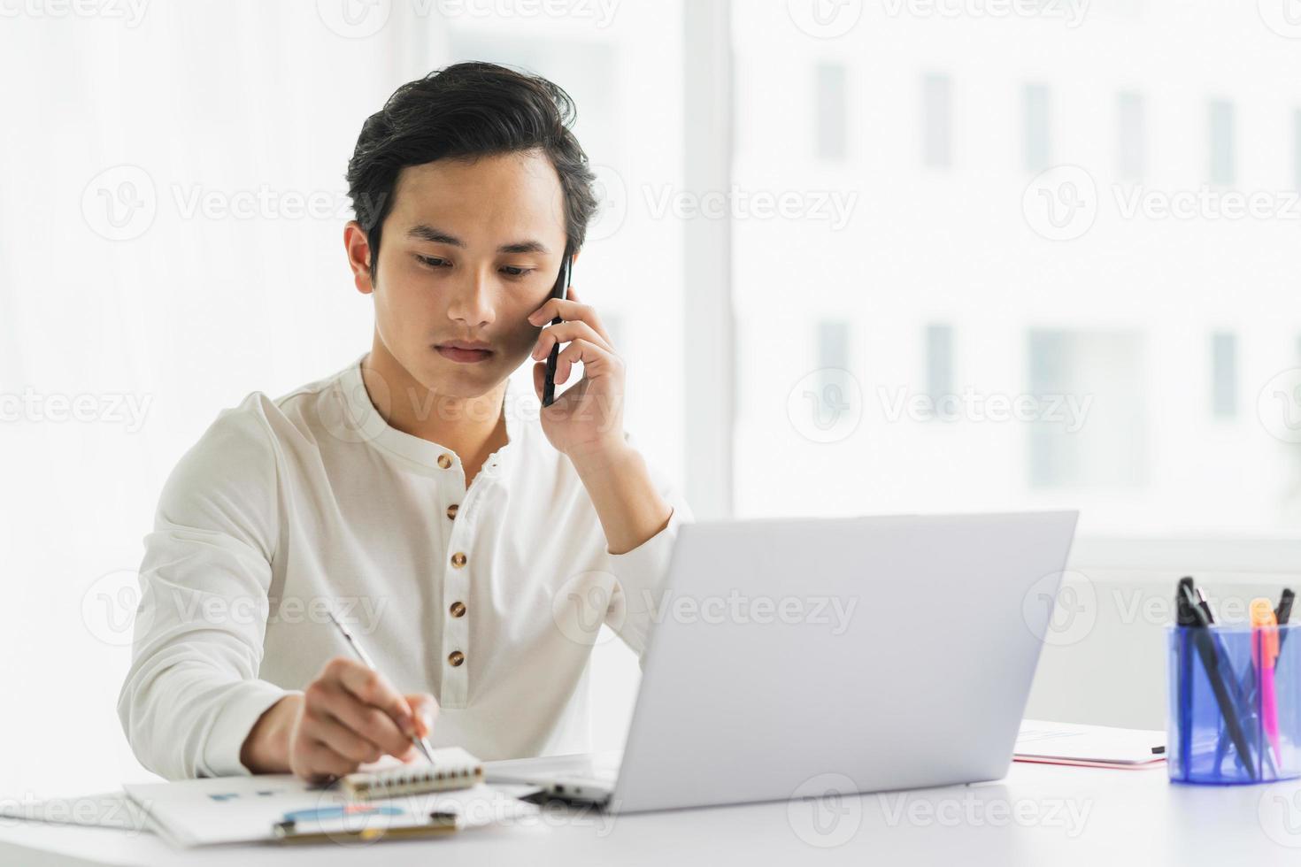 retrato da equipe masculina enquanto ouve o telefone enquanto faz anotações foto