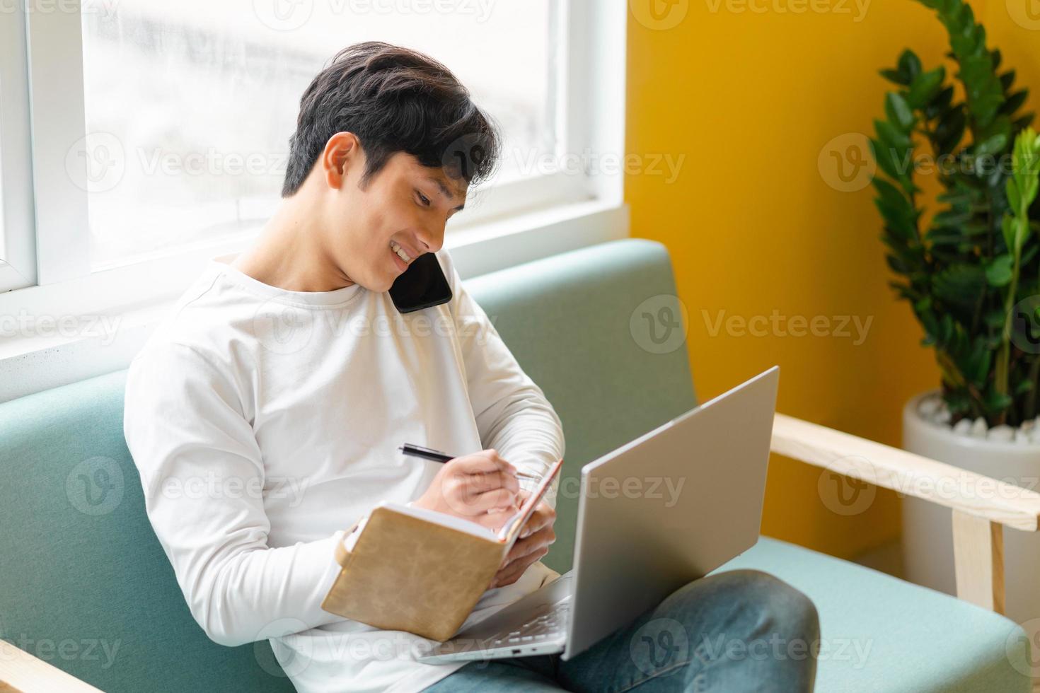 jovem asiático sentado trabalhando em casa foto