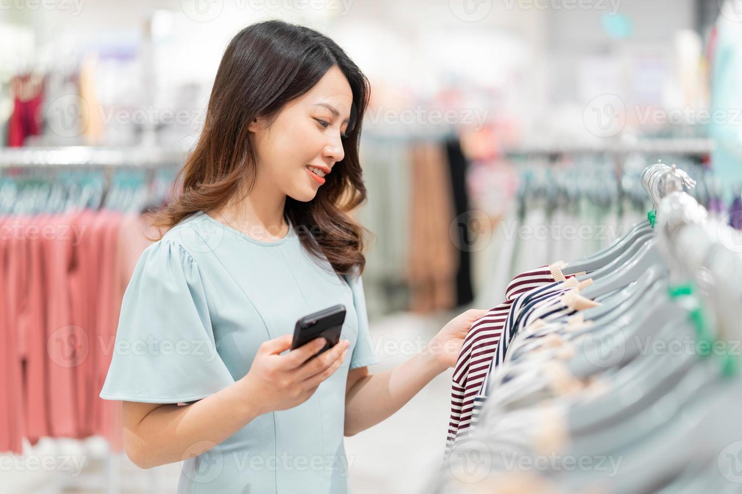 jovem está escolhendo comprar roupas no shopping foto