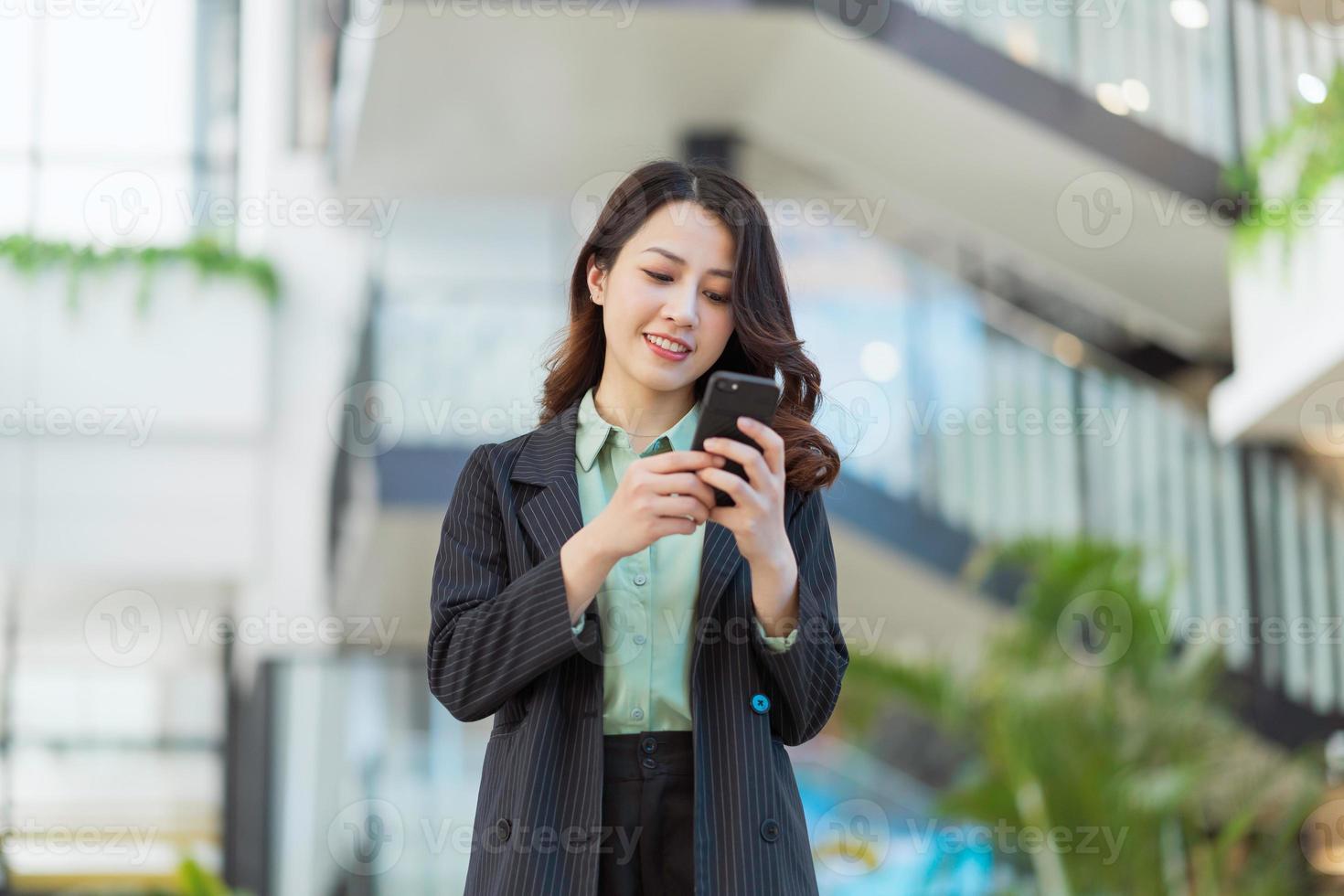 retrato de uma jovem diretora asiática segurando um telefone foto