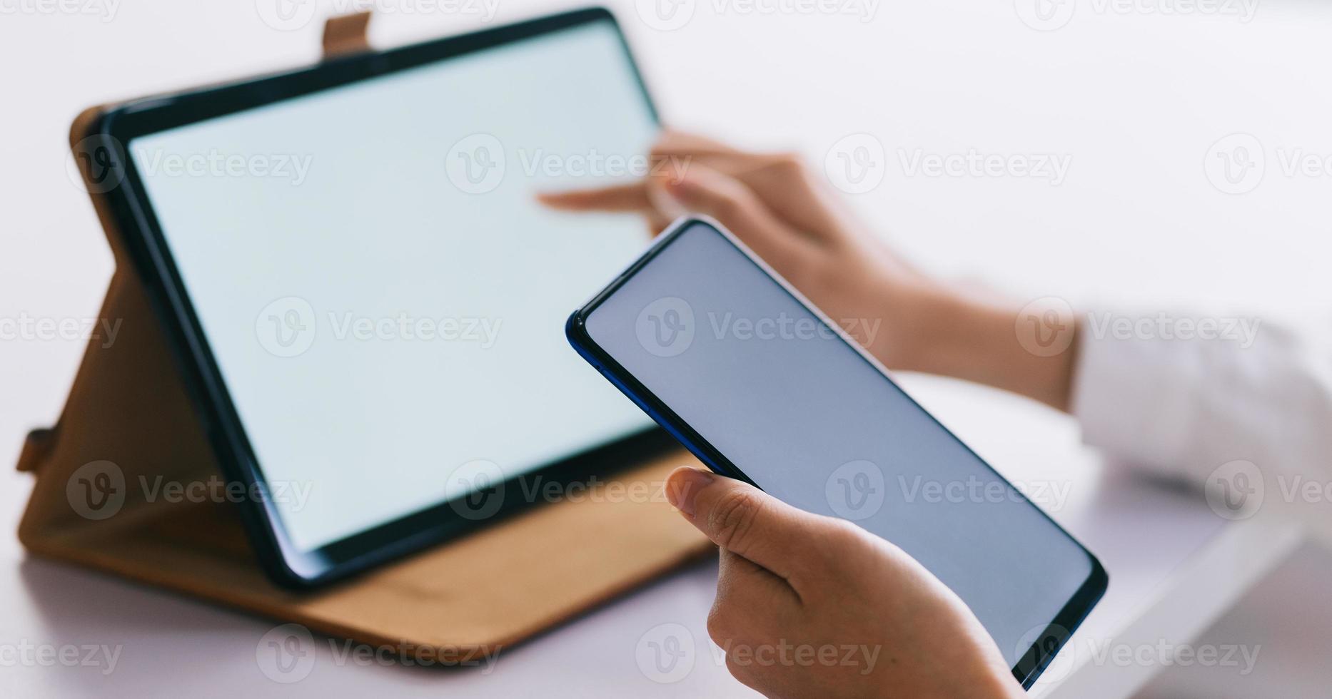 mulher asiática usando smartphone e tablet com tela em branco foto