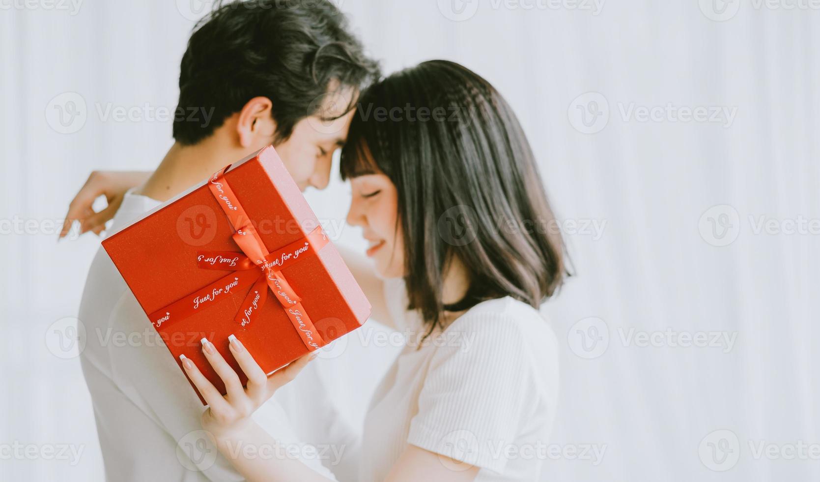 namorado asiático dando presentes para a namorada no dia dos namorados foto