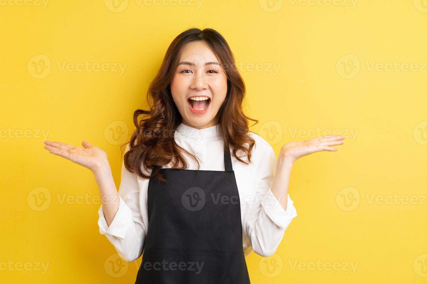 linda dona de casa com gesto isolado em fundo amarelo foto