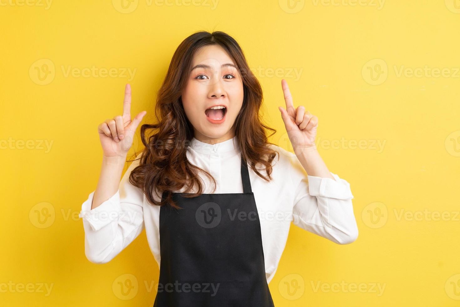 linda dona de casa com gesto isolado em fundo amarelo foto