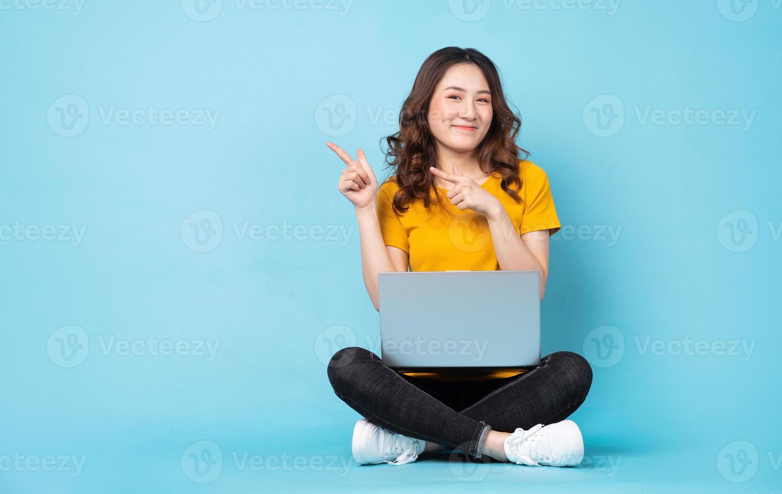 jovem sentada usando laptop com expressões e gestos no fundo foto