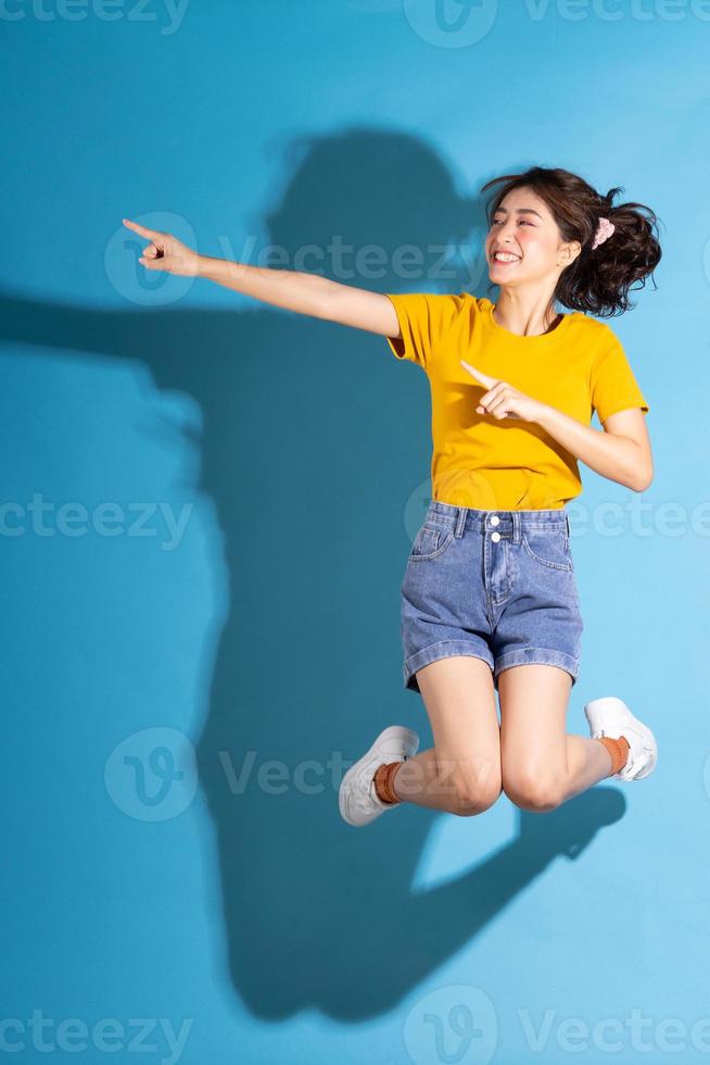 jovem asiática posando em fundo azul foto