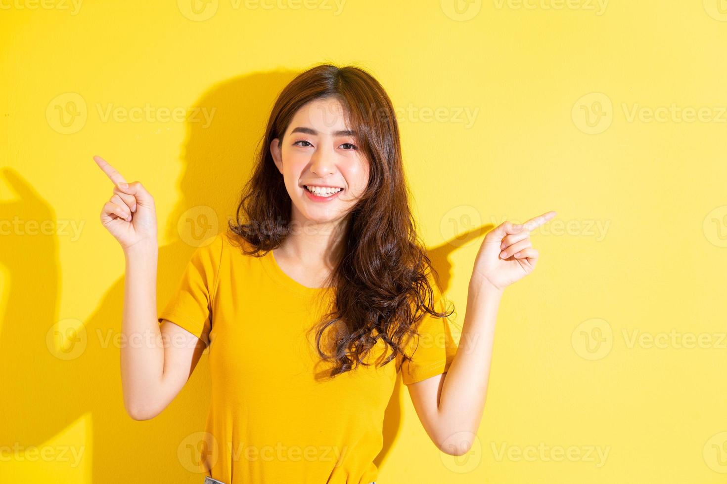 jovem asiática posando em fundo amarelo foto