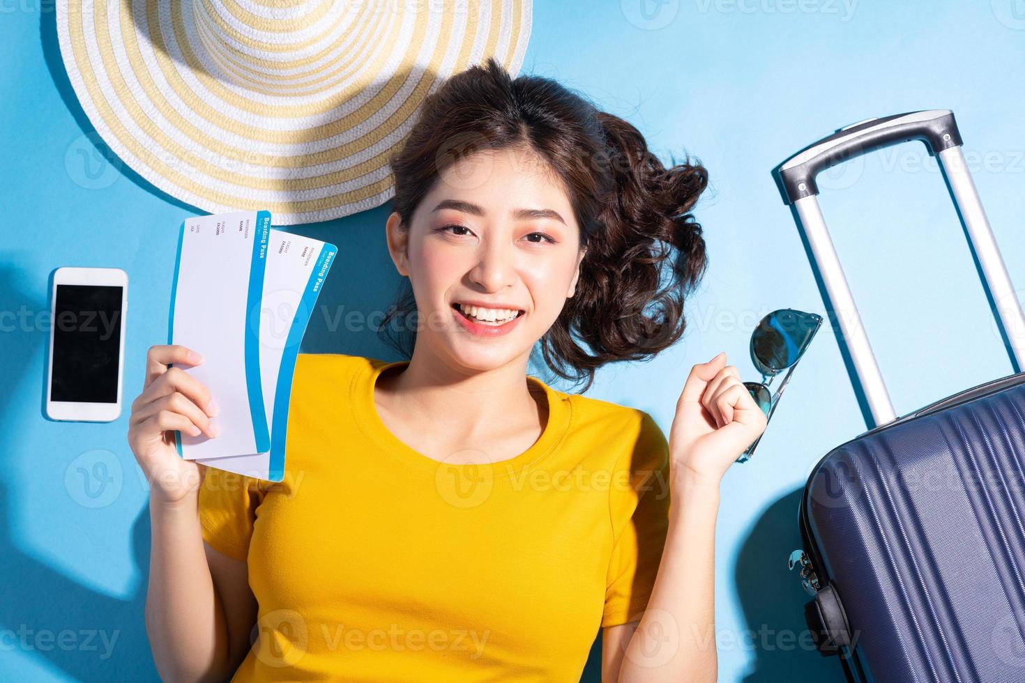 jovem mulher asiática sobre fundo azul, verão e conceito de viagens foto