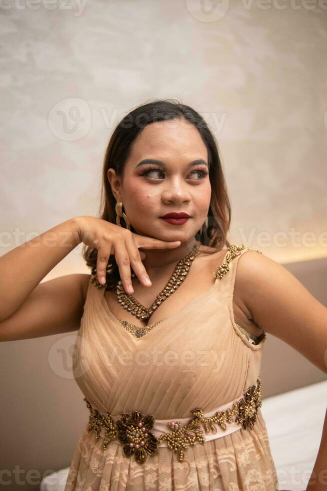 a ásia mulher é posando belas enquanto vestindo Maquiagem e a elegante festa vestir às uma hotel foto