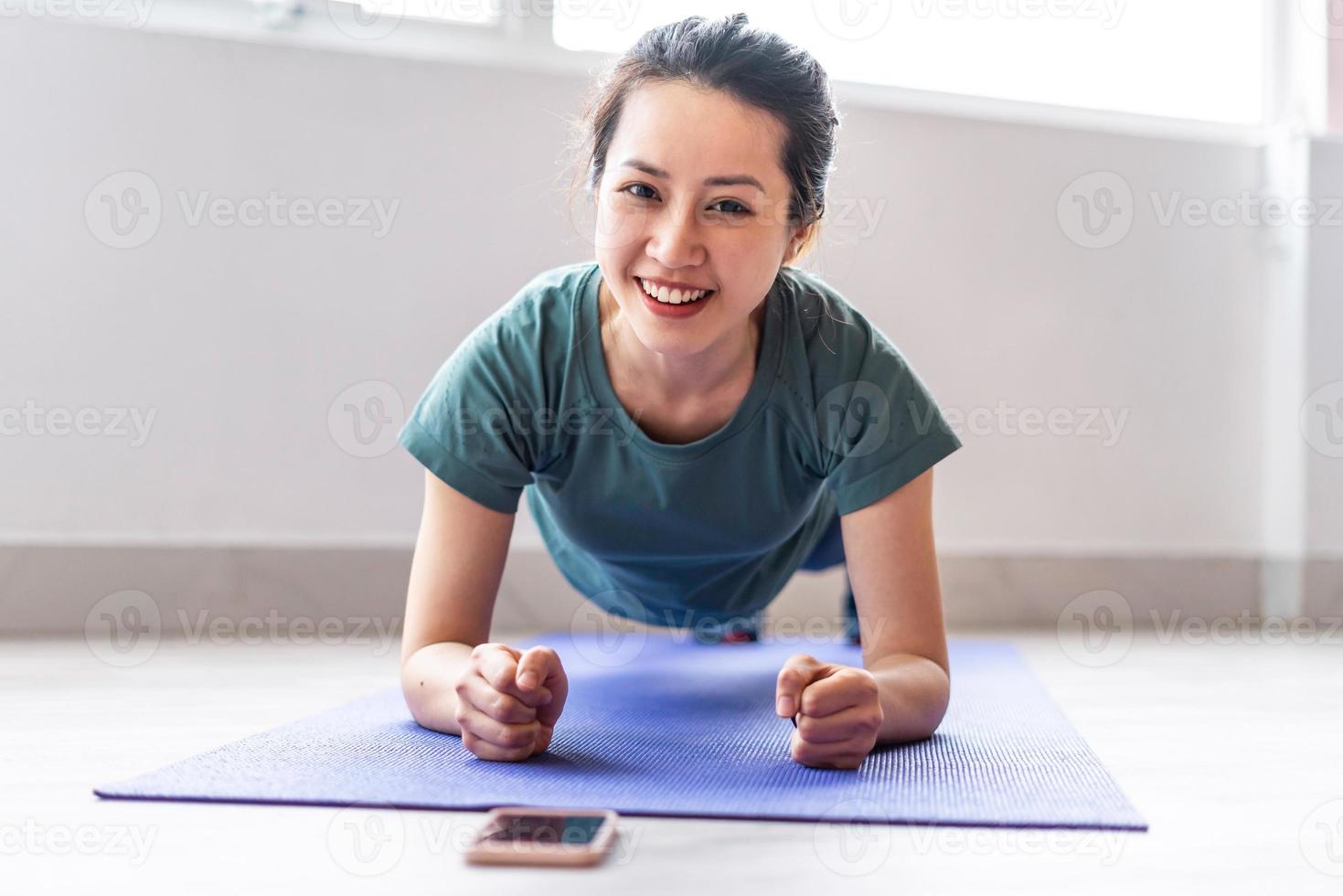 jovem fazendo exercícios em casa com uma expressão alegre foto