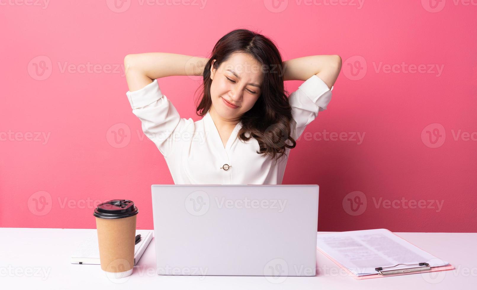 jovem empresária asiática sentada trabalhando com expressão no fundo foto