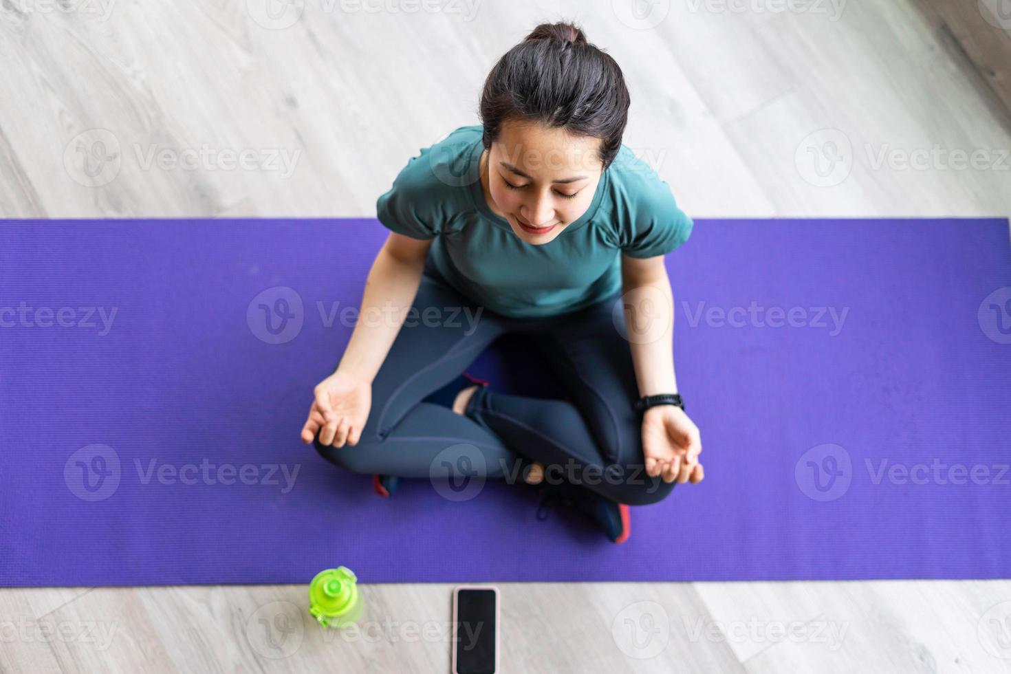 jovem fazendo exercícios em casa com uma expressão alegre foto