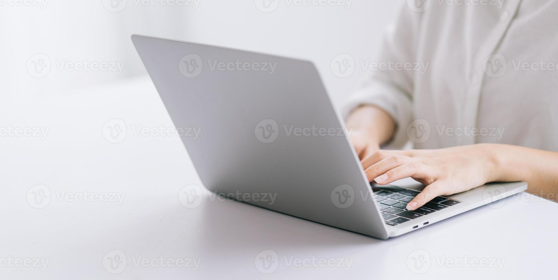 imagem recortada de mulher de negócios asiática usando laptop foto